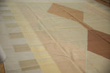Modern geometric Kilim weave showing interwoven copper brown and neutral diamond shapes.