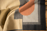 Hand woven kilim texture with black edge and geometric blocks of charcoal and grey.