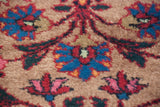 Hand-knotted pile showing vibrant palmettes and vinery on a dark beige field.