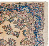Corner of a fine vintage Kerman carpet with Rococo-style motifs in sapphire blue and dusty rose on an ivory field.