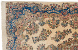 Elaborate Rococo-style border in sapphire blue and blush on a vintage Kerman rug corner.