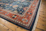 Terracotta border with floral motifs and navy palmettes on vintage Bijar rug corner.