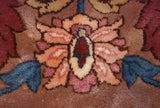 Close-up of a plush pile palmette in raspberry, wine red, ecru, and slate blue.