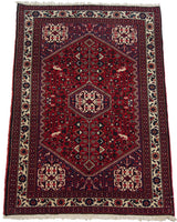 Vintage Persian Abadeh rug shown from an angle, displaying the plush red pile and central medallion.