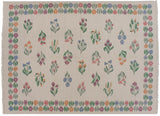 Pastel floral bouquets and fringed corner detail of the vintage Romanian Kilim.