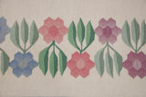Hand woven vintage Romanian Kilim with staggered ivory, blue, pink, mauve, and green floral pattern.