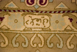 Close-up of a decorative cartouche and floral border in sky blue, beige, and dusty gold.