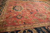 A vintage Agra carpet's copper field with oversized medallions and navy palmette border.