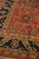 Vintage Agra carpet's plush pile, showing the navy palmette border and copper-toned field.