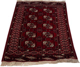 Vintage cherry red Yomud rug, visible geometric gul motifs and patterned side border.