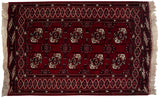 Vintage Yomud rug corner with cherry red geometric gul motifs and ivory fringe.