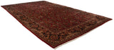 Vintage Sarouk carpet angled to show its length, ruby red field, and allover floral pattern.