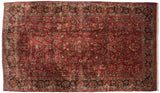 Balanced allover pattern of floral bouquets on a vintage ruby red and navy blue Sarouk carpet.