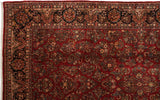 Detailed navy floral border and original side selvage on a vintage ruby red American Sarouk rug.
