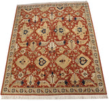 Angled view of a vintage Sultanabad rug with large floral and vine motifs in terracotta, ivory, and navy.