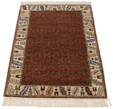 Serrated leaf border with nuanced weaver touches on a vintage Armenian rug's copper main field.