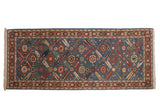 Vintage Armenian Veramin design rug runner with a floral lattice pattern on a denim blue field with terracotta and gold accents.
