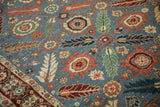 Elaborate floral buds and pinwheel motifs in terracotta and gold on the denim blue rug pile.