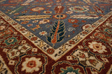 Close-up of a vintage Armenian rug's corner, showing animal motifs against the denim blue pile.