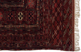 Detailed geometric borders and ivory fringe on the corner of a hand-knotted vintage Bokhara carpet.