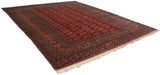 Angled view of a vintage Bokhara carpet's lustrous red pile and repeating geometric gul medallions.