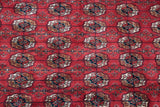Plush cherry red vintage Bokhara rug, displaying detailed navy, ivory, and coffee gul medallions.