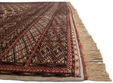 A side view of the Bokhara carpet's plush wool pile, geometric border, and intact ivory fringe.