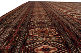 A low view down the repeating columns of gul medallions on a plush vintage Bokhara carpet.