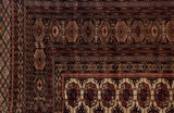 Intricate geometric gul medallions and multiple guard borders on a vintage Bokhara carpet corner.