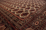 High-sheen wool pile on the detailed geometric borders and ivory field of a Bokhara rug.