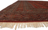 Plush wool pile, intricate geometric borders, and ivory fringe on a vintage Bokhara rug corner.