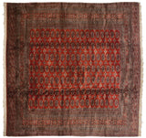 A vintage Pakistani Bokhara square carpet showing the high sheen and luster of the plush wool pile.