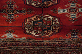 Fine detail of a Bokhara rug's elephant's footprint gul in red, navy blue, and apricot.