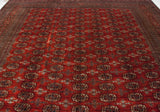A long view of a vintage Bokhara carpet displaying its multi-column gul medallion pattern.