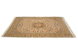 Angled view of a vintage Bulgarian Isfahan carpet showing its starburst medallion and saffron border.