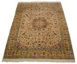 Angled view of a vintage Bulgarian Isfahan carpet, highlighting its starburst medallion and saffron yellow border.