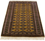 Pakistani Turkmen rug from an angle, showing interconnected geometric guls on a dusty gold field.