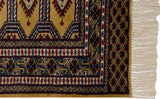 Detailed corner of a Turkmen rug with diamond-patterned borders and clean, original ivory fringe.