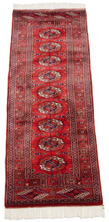 Detailed fine weave of repeating gul medallions in navy blue and ivory on a cherry red Bokhara runner.