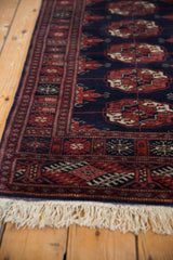 White fringe and detailed geometric border of a vintage Bokhara rug runner.
