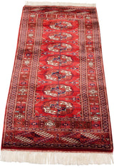 Fine weave, cherry red gul medallions, and ivory fringe at the Bokhara runner's corner.