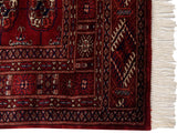 Fine weave on a wine red vintage Bokhara rug with navy geometric guls and fringe.
