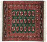 Vintage fine Bokhara square rug with repeating rust gul medallions on a mallard green field.