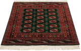 Angled view of a vintage Bokhara rug highlighting its plush mallard green pile and lustrous sheen.