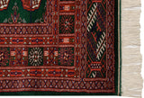 Vintage Bokhara rug corner showing geometric borders, intact selvage, and clean ivory fringe.