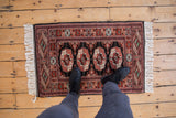 Vintage Pakistani Bokhara mat shown to scale, highlighting the plush wool and repeating gul pattern.