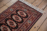The plush, full pile and intact side cord of a vintage Bokhara rug corner.