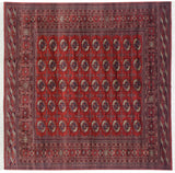 Vintage Bokhara square carpet with repeating gul medallions in cherry red, navy blue, and ivory.