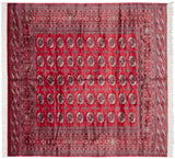 Symmetrical layout of multi-column gul medallions on a vintage cherry red Bokhara carpet.