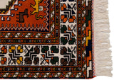 Vintage Indian Northwest Persian rug corner with rust, navy border, ivory ground motifs, and fringe.